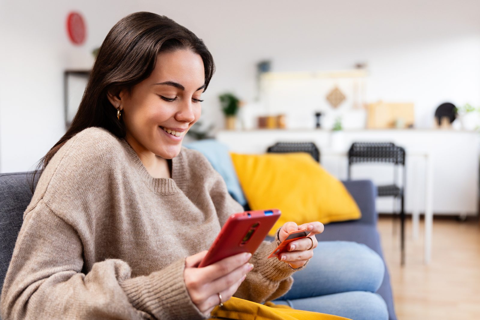GENCO member holding her debit card and phone