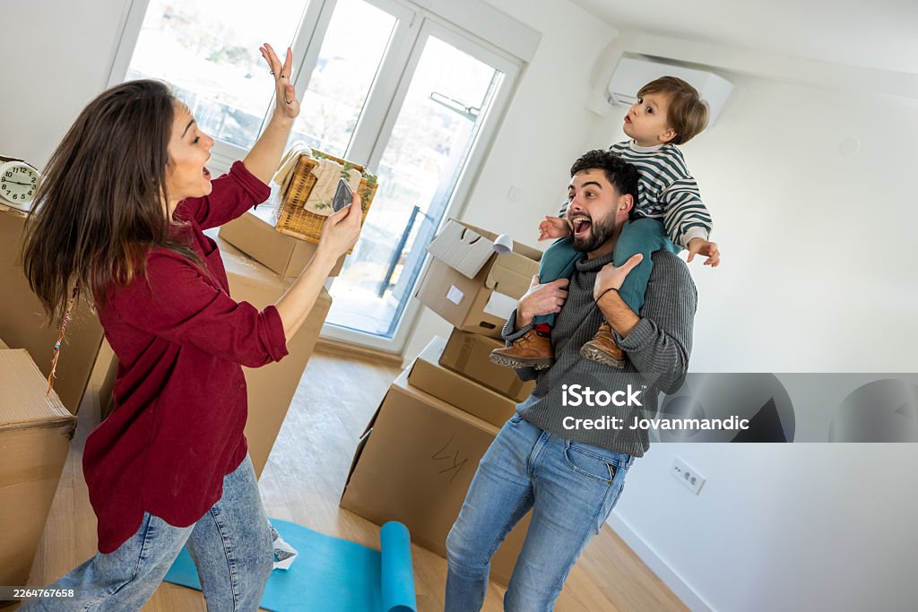 A family celebrating in their new home among moving boxes